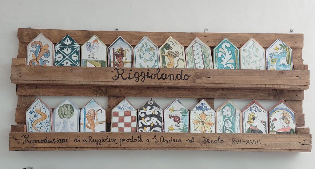 Pannello espositivo in legno con le riggiole, mattonelle esagonali in ceramica dipinta a mano, realizzate dal laboratorio Riggiolando